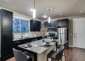 Thumbnail 1 of 28 - a kitchen with a large island with a granite countertop