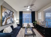 Thumbnail 2 of 28 - a living room with a blue couch and a large painting on the wall