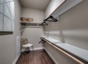 Thumbnail 5 of 28 - a spacious walk in closet in a bedroom with a desk and a chair