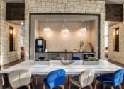 Thumbnail 11 of 28 - a large table with blue chairs and a kitchen in the background