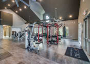 Thumbnail 12 of 28 - a spacious fitness center with exercise equipment and a large screen on the wall