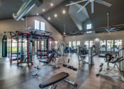 Thumbnail 14 of 28 - a spacious fitness center with exercise equipment and windows