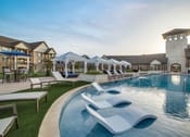 Thumbnail 18 of 28 - a resort style pool with lounge chairs and umbrellas