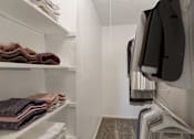 Thumbnail 6 of 42 - a walk in closet with white walls and shelves