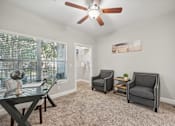 Thumbnail 8 of 40 - A room with a ceiling fan and three chairs.