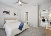 Thumbnail 14 of 45 - A bedroom with a bed, a ceiling fan, and a picture on the wall.