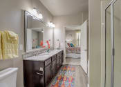 Thumbnail 11 of 50 - a bathroom with a shower and a sink and a mirror
