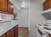 Thumbnail 11 of 37 - the kitchen of our studio apartment atrium with white appliances and wood cabinets