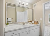 Thumbnail 9 of 32 - A bathroom with a white sink and a large mirror.
