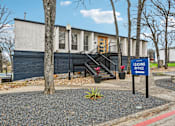 Thumbnail 38 of 79 - A blue sign with the words "LEASING OFFICE" stands in front of a building.