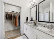 Thumbnail 7 of 43 - A bathroom with a white vanity and a mirror above it.