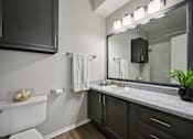 Thumbnail 15 of 45 - A bathroom with a white toilet and a mirror above a sink.