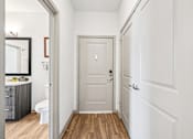 Thumbnail 34 of 61 - A white door is in the middle of a hallway.