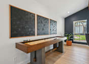 Thumbnail 52 of 79 - A room with a shuffleboard table and three artworks on the wall.
