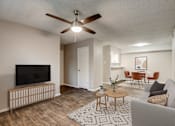 Thumbnail 8 of 42 - a living room with a ceiling fan and a dining room in the background