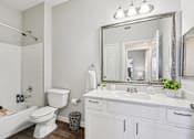 Thumbnail 12 of 70 - A white bathroom with a large mirror and a white bathtub.