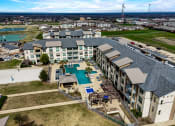Thumbnail 23 of 33 - an aerial view of a building with a pool and other buildings