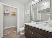 Thumbnail 20 of 40 - A bathroom with a white toilet, a sink, and a mirror.