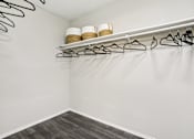Thumbnail 13 of 37 - A white closet with two shelves and hangers.