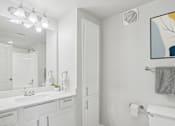 Thumbnail 32 of 70 - A bathroom with a white sink and a white toilet.