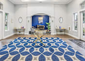 Thumbnail 15 of 27 - A room with a blue and white patterned rug in the center.