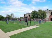 Thumbnail 34 of 48 - a fenced in dog park with agility equipment and houses in the background