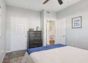 Thumbnail 15 of 70 - A bedroom with a bed, dresser, and ceiling fan.