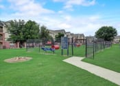 Thumbnail 35 of 48 - a fenced in park with a playground and houses in the background