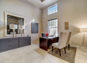 Thumbnail 30 of 42 - a home office with a dark wood desk and white chairs