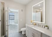 Thumbnail 13 of 55 - A modern bathroom with a sleek backlit mirror.