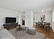 Thumbnail 1 of 26 - A living room with a grey sofa, a black television, and a grey coffee table.