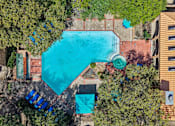 Thumbnail 40 of 45 - An aerial view of a swimming pool surrounded by trees and buildings.
