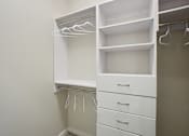 Thumbnail 14 of 55 - A closet with built-in drawers and shelves.