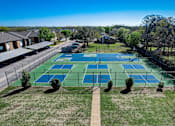 Thumbnail 35 of 42 - an aerial view of a tennis court with tennis courts on the grass