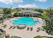 Thumbnail 27 of 32 - A large swimming pool surrounded by lounge chairs and umbrellas.