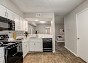 Thumbnail 10 of 42 - a kitchen with white cabinetry and black appliances