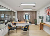 Thumbnail 34 of 47 - A modern office space with a wooden desk, two chairs, and a large mirror on the wall.