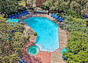 Thumbnail 41 of 45 - An aerial view of a swimming pool surrounded by trees.