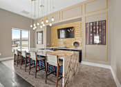 Thumbnail 27 of 29 - A modern kitchen with a bar area and a television mounted on the wall.