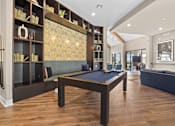 Thumbnail 23 of 29 - A pool table is in the middle of a room with a bookshelf and a couch.