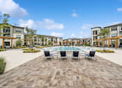 Thumbnail 13 of 29 - A large square with a pool in the middle and chairs around it.