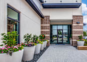 Thumbnail 17 of 36 - Landscaped walkway lined with large planters leading to the main entrance.
