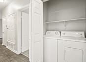 Thumbnail 21 of 48 - A white laundry room with a washer and dryer.