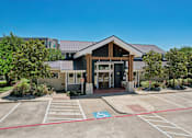Thumbnail 22 of 55 - A building with a parking lot in front of it.
