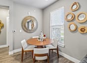 Thumbnail 6 of 36 - A dining room with a round table and chairs.