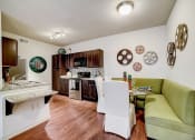 Thumbnail 3 of 42 - a kitchen and living room with a green couch and wood flooring
