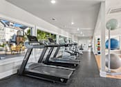 Thumbnail 53 of 70 - A gym with treadmills and a large ball.