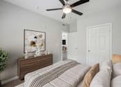 Thumbnail 26 of 70 - A bedroom with a bed, dresser, and a ceiling fan.