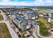 Thumbnail 32 of 33 - an aerial view of an apartment complex with cars parked in front of it