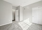Thumbnail 19 of 48 - A room with a white door and a carpeted floor.